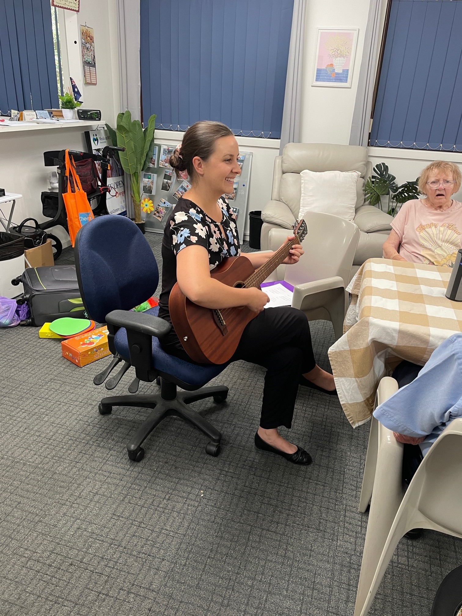 Registered Music Therapist playing guitar in a one-on-one session with a resident